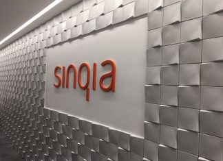 Foto de parede com o logo da Sinqia em laranja no meio